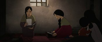 Movie still from “The Breadwinner” (2017), directed by Nora Twomey – A girl writing on a book while another girl looks on; Medium shot, High angle