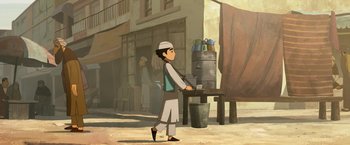 Movie still from “The Breadwinner” (2017), directed by Nora Twomey – An asian boy standing in front of a table; Wide shot, Low angle