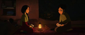 Movie still from “The Breadwinner” (2017), directed by Nora Twomey – Two women sitting in front of an oil lamp; Medium shot, High angle