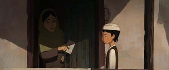 Movie still from “The Breadwinner” (2017), directed by Nora Twomey – An animated scene of a boy holding a paper plane; Medium shot, Over the shoulder angle