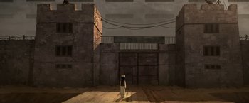 Movie still from “The Breadwinner” (2017), directed by Nora Twomey – A person standing in front of a brick building; Extreme Wide shot, Overhead angle