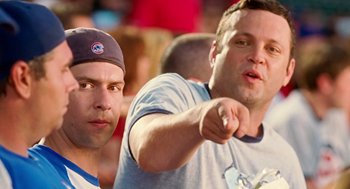 Movie still from “The Break-Up” (2006), directed by Peyton Reed – A man pointing at something while another man looks on; Medium shot, Over the shoulder angle