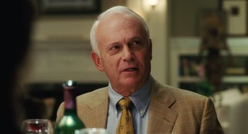 Movie still from “The Break-Up” (2006), directed by Peyton Reed – An older man wearing a suit and a tie; Close Up shot, Over the shoulder angle