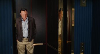 Movie still from “The Break-Up” (2006), directed by Peyton Reed – A man standing next to a mirror in a room; Medium shot, Over the shoulder angle
