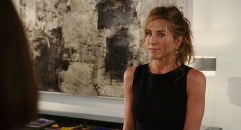 Movie still from “The Break-Up” (2006), directed by Peyton Reed – A woman in a black dress is standing in front of a wall; Medium shot, Over the shoulder angle