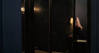 A person standing next to a window in a dark room