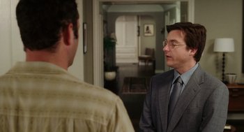 A man in a suit and tie standing next to another man