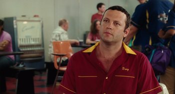 Movie still from “The Break-Up” (2006), directed by Peyton Reed – A man in a red and yellow shirt is looking to his left; Close Up shot, Over the shoulder angle