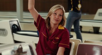 Movie still from “The Break-Up” (2006), directed by Peyton Reed – A woman sitting in a chair raising her hand; Medium shot, Low angle