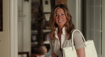 Movie still from “The Break-Up” (2006), directed by Peyton Reed – A woman with long brown hair is holding a white purse; Medium shot, Over the shoulder angle