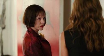 Movie still from “The Break-Up” (2006), directed by Peyton Reed – A woman in a red jacket is looking at another woman in a black dress; Close Up shot, Over the shoulder angle