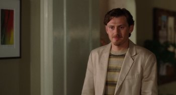 Movie still from “The Break-Up” (2006), directed by Peyton Reed – A man wearing a jacket standing in front of a mirror; Medium shot, Over the shoulder angle