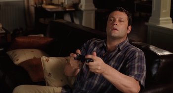 Movie still from “The Break-Up” (2006), directed by Peyton Reed – A man sitting on a couch playing a video game; Medium shot, High angle