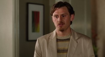 Movie still from “The Break-Up” (2006), directed by Peyton Reed – A man in a beige jacket and striped sweater; Close Up shot, Over the shoulder angle