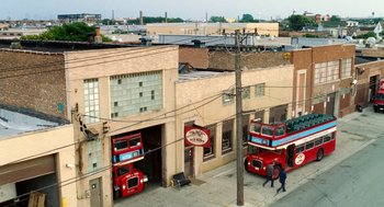 Movie still from “The Break-Up” (2006), directed by Peyton Reed – Two red double decker buses parked in front of a building; Extreme Wide shot, High angle