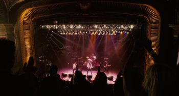 Movie still from “The Break-Up” (2006), directed by Peyton Reed – A group of people on a stage with lights in the background; Extreme Wide shot, Overhead angle