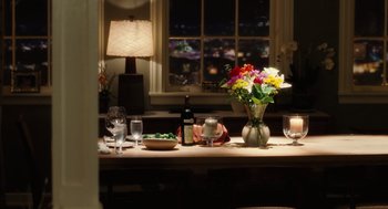 Movie still from “The Break-Up” (2006), directed by Peyton Reed – A dinner table set for a meal with flowers and wine; Wide shot, High angle