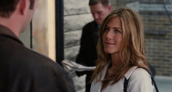 Movie still from “The Break-Up” (2006), directed by Peyton Reed – A woman with long brown hair standing in front of a building; Close Up shot, Over the shoulder angle