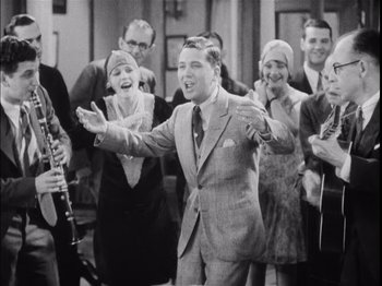 Movie still from “The Broadway Melody” (1929), directed by Harry Beaumont – An old photo of a group of people singing; Medium shot, High angle