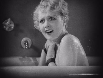 Movie still from “The Broadway Melody” (1929), directed by Harry Beaumont – A woman sitting in a bath tub with a towel around her neck; Close Up shot, High angle