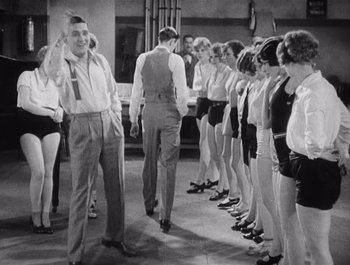 Movie still from “The Broadway Melody” (1929), directed by Harry Beaumont – A group of men and women standing next to each other; Wide shot, High angle