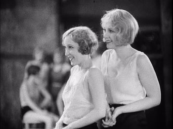 Movie still from “The Broadway Melody” (1929), directed by Harry Beaumont – A couple of women standing next to each other; Medium shot, Low angle