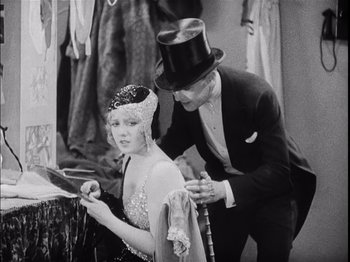 Movie still from “The Broadway Melody” (1929), directed by Harry Beaumont – A man and a woman in formal wear and top hats; Medium shot, High angle