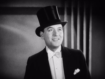 Movie still from “The Broadway Melody” (1929), directed by Harry Beaumont – A man wearing a suit and a top hat; Close Up shot, Low angle