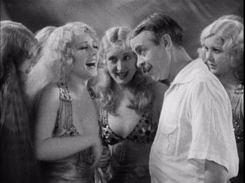 Movie still from “The Broadway Melody” (1929), directed by Harry Beaumont – A group of people standing next to each other; Medium shot, Over the shoulder angle