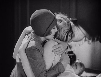 Movie still from “The Broadway Melody” (1929), directed by Harry Beaumont – Two people are hugging each other in a black and white photo; Medium shot, Low angle