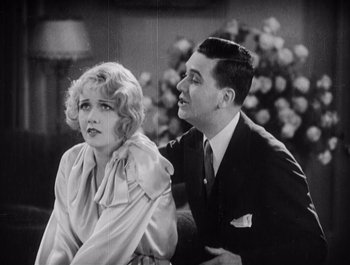 Movie still from “The Broadway Melody” (1929), directed by Harry Beaumont – A man and a woman sitting next to each other; Medium shot, Low angle