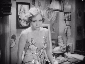Movie still from “The Broadway Melody” (1929), directed by Harry Beaumont – An old photo of a woman posing in a dress; Medium shot, High angle