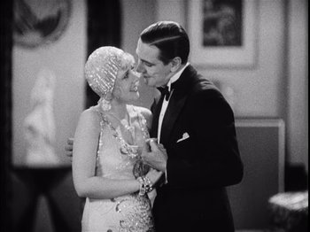 Movie still from “The Broadway Melody” (1929), directed by Harry Beaumont – A man and a woman kissing each other in front of a mirror; Medium shot, Low angle