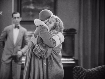 Movie still from “The Broadway Melody” (1929), directed by Harry Beaumont – Two people hugging each other in front of a piano; Medium shot, Over the shoulder angle
