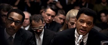 Movie still from “Ali” (2001), directed by Michael Mann – A group of men and women in suits and ties; Close Up shot, Over the shoulder angle