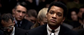 Movie still from “Ali” (2001), directed by Michael Mann – A man in a black suit and a white tie; Close Up shot, Over the shoulder angle