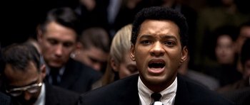 Movie still from “Ali” (2001), directed by Michael Mann – A person wearing a suit and tie; Close Up shot, Over the shoulder angle