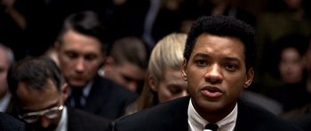 Movie still from “Ali” (2001), directed by Michael Mann – A man in a black suit and a tie; Close Up shot, Over the shoulder angle