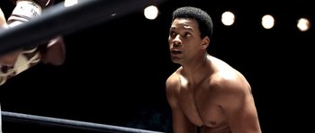 Movie still from “Ali” (2001), directed by Michael Mann – A man with no shirt in a boxing ring; Close Up shot, High angle