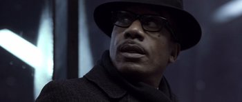 Movie still from “Ali” (2001), directed by Michael Mann – A person wearing glasses and a hat; Close Up shot, Low angle