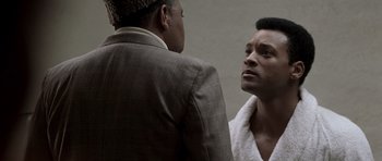 Movie still from “Ali” (2001), directed by Michael Mann – Two men in suits are talking to each other; Close Up shot, Over the shoulder angle