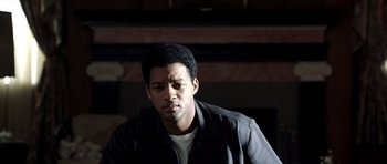 Movie still from “Ali” (2001), directed by Michael Mann – A man in a black jacket is looking at the camera; Close Up shot, Low angle