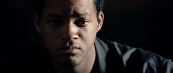 Movie still from “Ali” (2001), directed by Michael Mann – A man's face in a black shirt; Extreme Close Up shot, Over the shoulder angle
