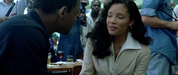 Movie still from “Ali” (2001), directed by Michael Mann – A man and a woman sitting at a table with other people; Close Up shot, Over the shoulder angle
