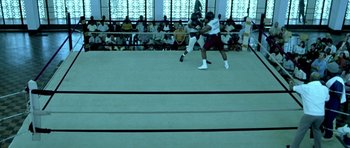 Movie still from “Ali” (2001), directed by Michael Mann – Two men are fighting in a boxing ring; Wide shot, Overhead angle