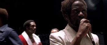 Movie still from “Ali” (2001), directed by Michael Mann – A man in a white shirt is looking to his left; Close Up shot, Low angle