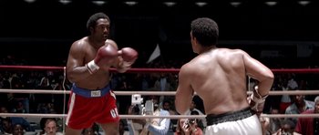 Movie still from “Ali” (2001), directed by Michael Mann – Two boxers in a boxing ring during a match; Medium shot, Over the shoulder angle
