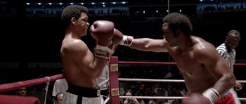 Movie still from “Ali” (2001), directed by Michael Mann – Two boxers in a boxing ring during a match; Medium shot, Over the shoulder angle