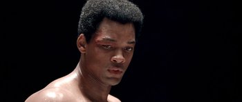 Movie still from “Ali” (2001), directed by Michael Mann – A person with a black face; Close Up shot, High angle