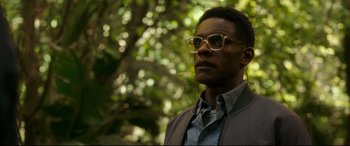 Movie still from “Godzilla vs. Kong” (2021), directed by Adam Wingard – A man wearing glasses and a jacket looking to his left; Close Up shot, Low angle